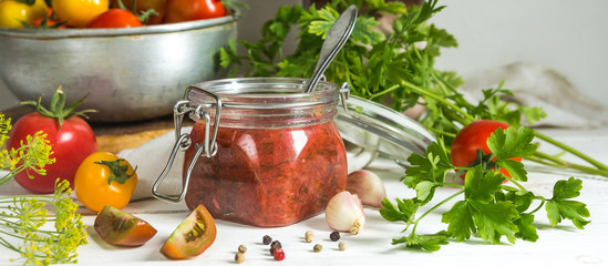Tomato sauce and fresh tomatoes, garlic, dill, parsley on a light wooden background still life in vintage rustic style