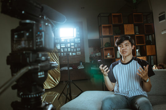 asian young man vlogger make video review about of new type smartphone series with recorded with the camera