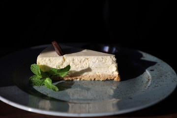 a piece of cake cheesecake on a plate decorated with a sprig of mint