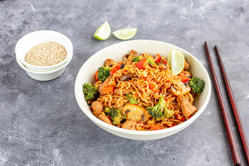 Ramen Noodles with Broccoli, Bell Pepper, Mushroom, and Chicken in a Bowl with Chopsticks High Angle Photo.