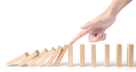 Hand stopping the Domino effect stopped by unique