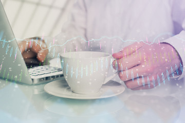 Double exposure of graph with man typing on computer in office on background. Concept of hard work.