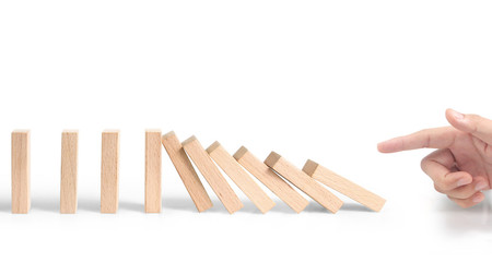 Hand stopping the Domino effect stopped by unique