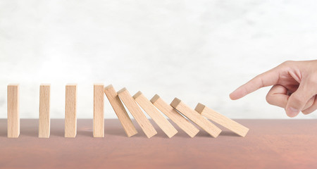 Hand stopping the Domino effect stopped by unique