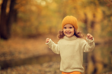 happy girl running in the autumn park at daytime