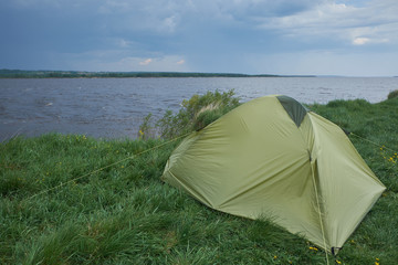 Tent by the river in cloudy weather