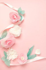 Greeting card with paper flowers on rose background.