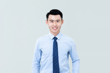 Asian man in business attire facing camera and smiling