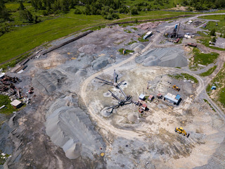 Aerial view of a small plant for the production and cleaning rubble and cement near the heaps of building materials, the tractors and trucks transports the finished product. Mining in quarry.