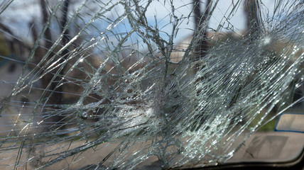 Broken car after an accident. Broken car glass. Broken windshield of car after collision. Robbers smashed glass. Abandoned ransacked car with broken windows. Crime with car