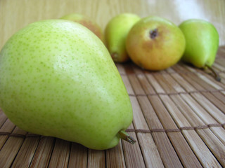 Green pears on a wooden background.