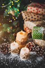 Merry Christmas and happy New year. Candle and Christmas toys on a wooden table. Bokeh. Selective focus.