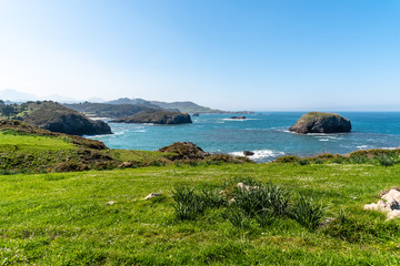 Scenic view of sea against blue sky in rocky coast
