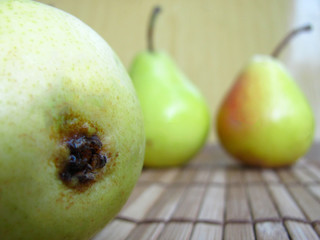 Green pears on a wooden background.