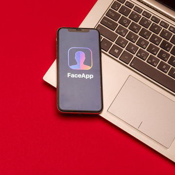 Tula, Russia - AUGUST 19, 2019: Face app displayed on a iphone X near modern laptop on desk