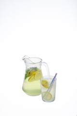 Lemonade jug with ice and glass on a white background. Isolated, copyspace