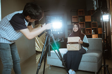 Fototapeta na wymiar Asian hijab woman making unboxing review recording video for vlog and social media