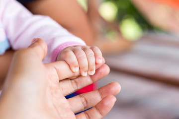 Obraz na płótnie Canvas Little handle newborn baby in mom's big hand.