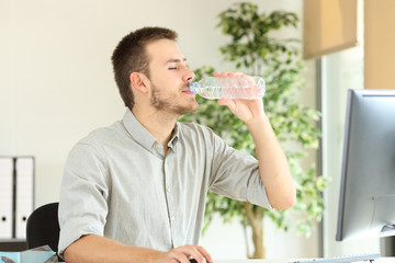 Office worker working and drinking bottled water