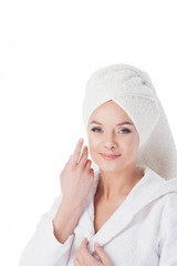 Beauty treatments after the bath. Portrait of a young beautiful woman in a Terry robe and with a towel on her head.