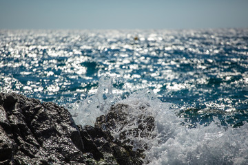 sea wave splashes over stone