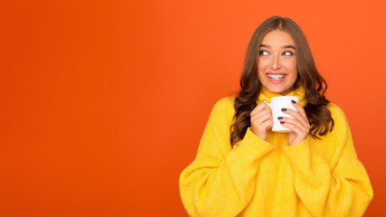 Winter holidays. Girl in sweater enjoying hot chocolate