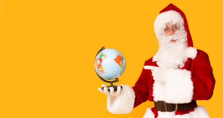 Santa Claus holding globe and showing North Pole with finger