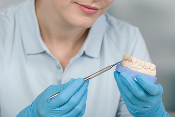 close up of dental technician works on artificial dention or implant in dental laboratory