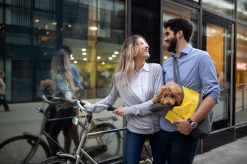 Beautiful couple walking dogs and bicycles outdoors in city