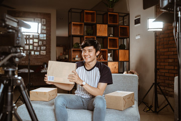 Young man making unboxing review recording video for vlog and social media