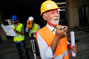 Architects, business manager and engineer meeting project at construction site