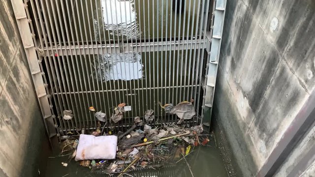 Canal spillway with trash stuck in filtering grate static shot 