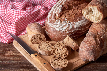 Still life with sliced loaf of bread. Kitchen knife and old wooden table top