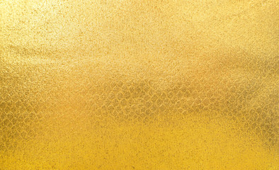 Fototapeta premium Shiny yellow gold fabric texture. Surface, pattern of rough abstract cloth matte background. Design in your work decoration backdrop, concept copy space for text.