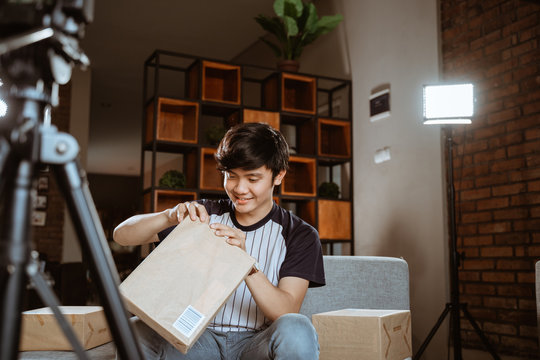 Asian Young Man Making Unboxing Review Recording Video For Vlog And Social Media