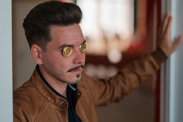 young man with bitcoins in the eye sockets. financier. business meeting