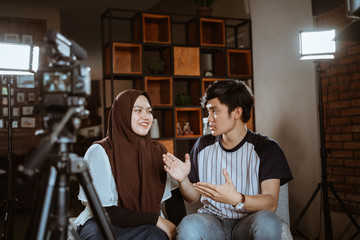 Fototapeta na wymiar Asian couple blogger recording vlog talking to camera when work at home
