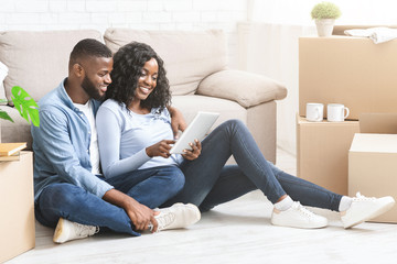 Black woman showing her man ideas for interior on tablet