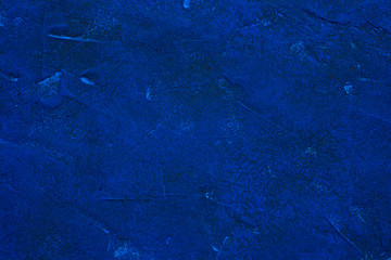 Fragment of a wall painted with blue paint. Abstract background.