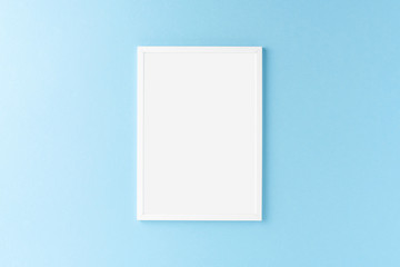 White picture frame on blue background. Mockup with copyspace