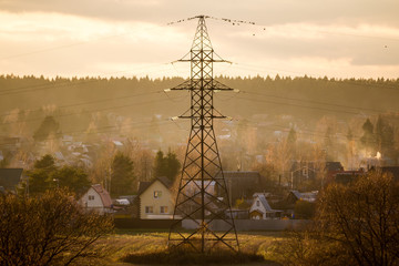 Power lines against the background of summer cottages and houses, evening haze