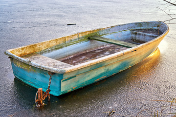 Obraz premium Old rowboat on a frozen lake in winter.