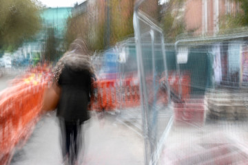 Long exposure of pedestrian walking along the street - intentional camera shake to introduce an...