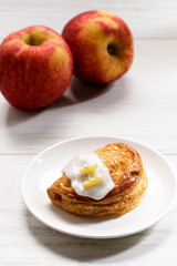 piece of cinnamon apple pie on a white plate with fresh apple in background, autumn food concept