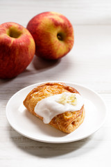 piece of cinnamon apple pie on a white plate with fresh apple in background, autumn food concept