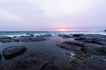 Fototapeta na wymiar Slightly red colour in a overcast sunrise over the beach.