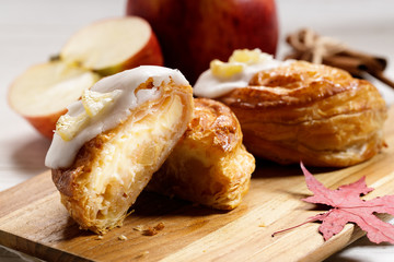 piece of cinnamon apple pie on a wooden board with fresh apple in background, autumn food concept