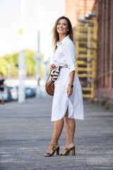 Happy young business woman walking on the street.