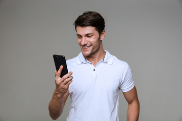 Positive young man using mobile phone.