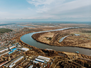 A large river goes into the distance in the city. Settlement and nature-panorama.